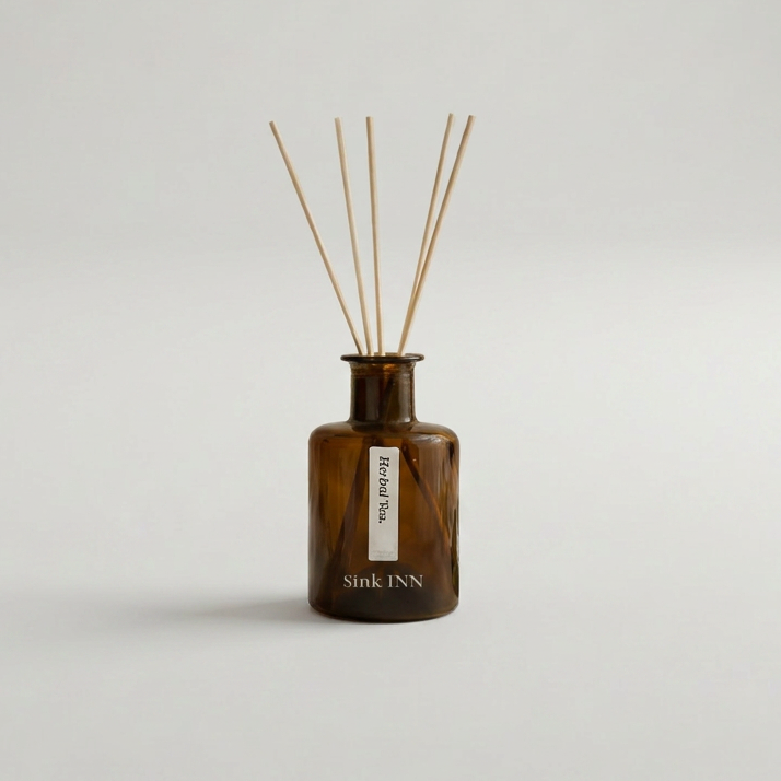 Brown diffuser bottle with wooden sticks on a light gray background